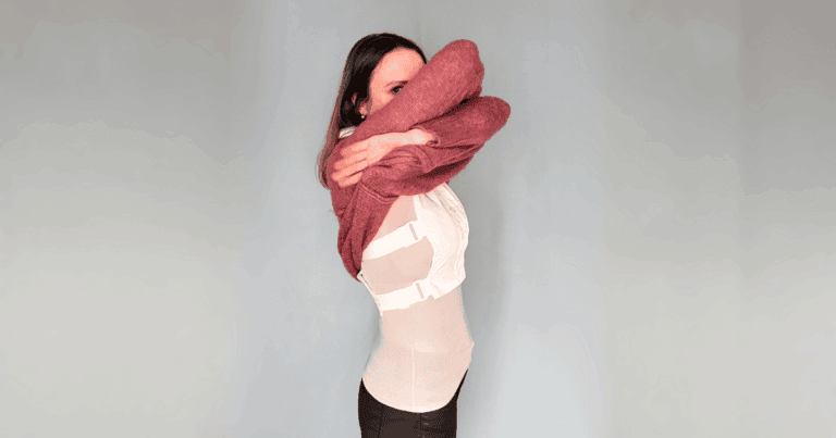 Eine Frau zieht ihren Pulli aus, darunter ist der Blusenkragen erkennbar