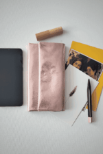 Flatlay Ansicht des Portemonnaies mit Handy, Karten, Stift und Lippenstift