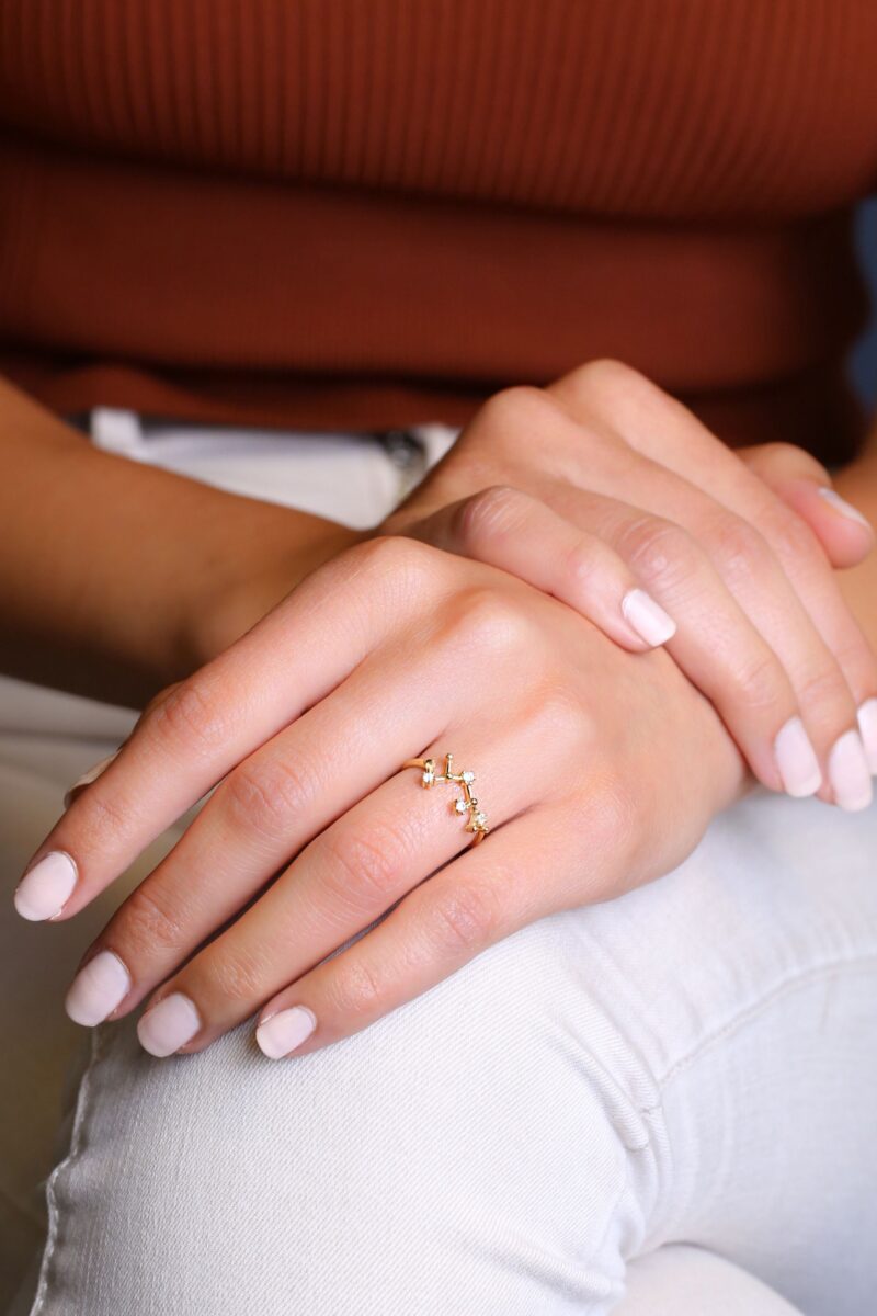 weibliche Hände mit Ring mit Schütze (sagittarius)-Sternzeichen-Konstellation in roségold 925 Sterlingsilber