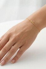 Armband aus Silber mit Blattzweig-Anhänger von Pastel Studio, and Handgelenk eines Models