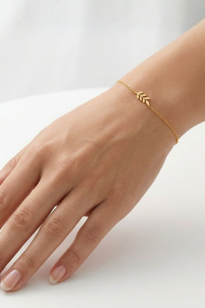 Armband aus Silber mit Blattzweig-Anhänger von Pastel Studio, and Handgelenk eines Models
