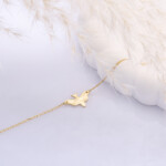 Armband aus 925 Sterlingsilber mit Vogel, Vermeil vergoldet, auf zartem Hintergrund drapiert